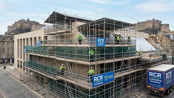 RCR Scaffolding Solutions team erecting a large-scale commercial scaffold in front of a Scottish castle skyline, highlighting 40 years of experience.