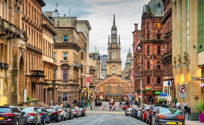 High-capacity tenement scaffolding tower erected by RCR Scaffolding Solutions on a traditional red sandstone block in Glasgow city center, providing safe multi-story access for complex stonework restoration and roof repairs with 40 years of local expertise and full CISRS safety compliance.